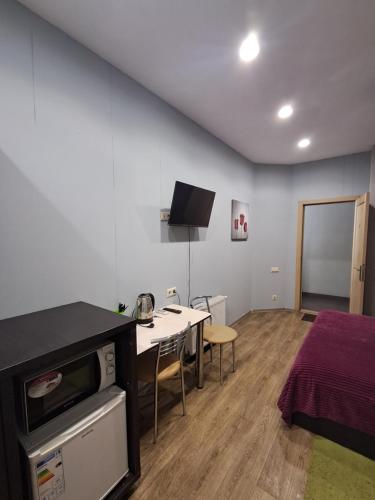 a room with a kitchen and a table and a bed at Апартаменти "PLATFORMA" поруч з Південним вокзалом in Kharkiv