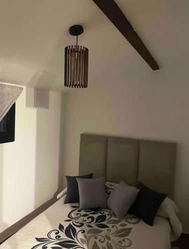 a bedroom with a bed with a chandelier at Casa del campo in Souani