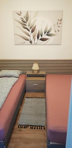 a bedroom with a bed and a table with a picture on the wall at Borostyán nyaralóház in Fonyód