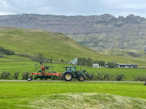 a tractor parked on a road in a field at Amma Jóna rooms in Ásólfsskáli