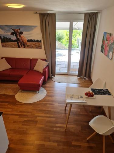 a living room with a red couch and a table at Maisonette-Wohnung inmitten der Natur in Wald