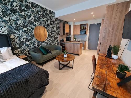 a bedroom with a bed and a couch and a table at Luxury Menlyn Maine Apartment in Pretoria