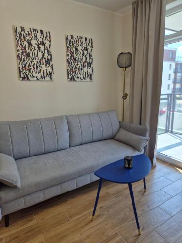 a living room with a couch and a blue table at Maczka Apartament in Łódź