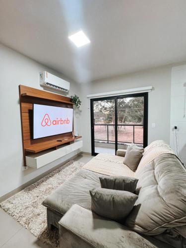 a living room with a large bed and a flat screen tv at APTO 100% Climatizado - Experiência Premium - Único na Cidade - Garagem Privativa p/ carros ñ atende caminhonetes. in Três Lagoas