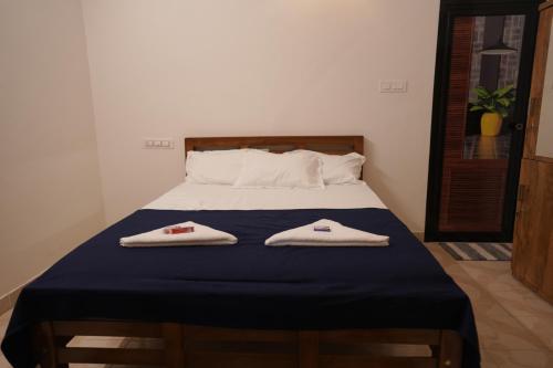 ein Schlafzimmer mit einem Bett mit zwei Handtüchern darauf in der Unterkunft The Beach Hive in Kappil
