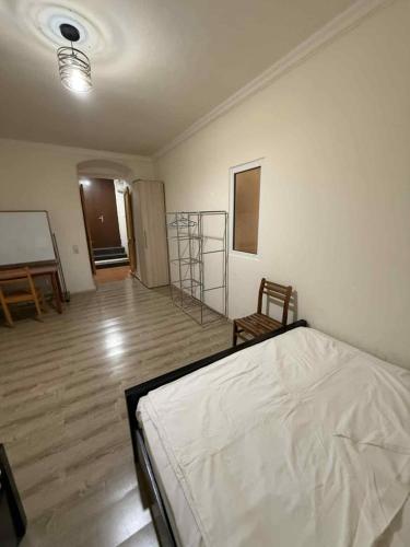 a bedroom with a white bed and a wooden floor at Apartment for Daily Rent in the Heart of Tbilisi in Tbilisi City