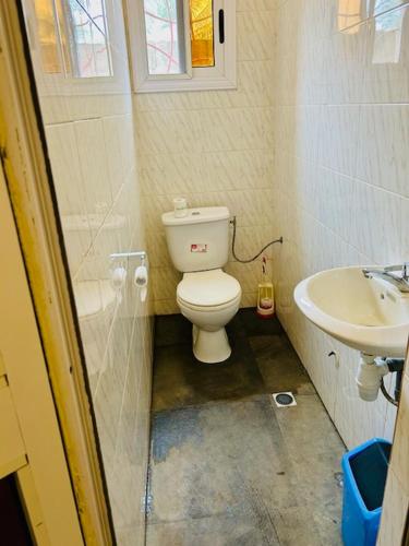 a small bathroom with a toilet and a sink at Résidence A2 in Komé