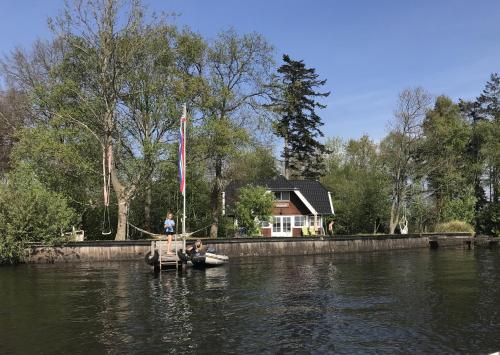 two people in a small boat in the water at Vakantiehuis Paterswoldsemeer - Potjewol in Haren
