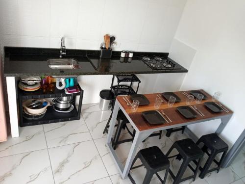 een keuken met een wastafel en een tafel en stoelen bij Guará Apart 2 in Guaratuba