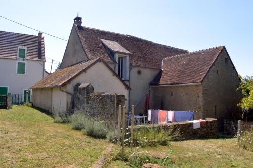 an old house with a clothes line in front of it at Le Gîte du Hérisson, Gîte de charme et de confort in Le Menoux