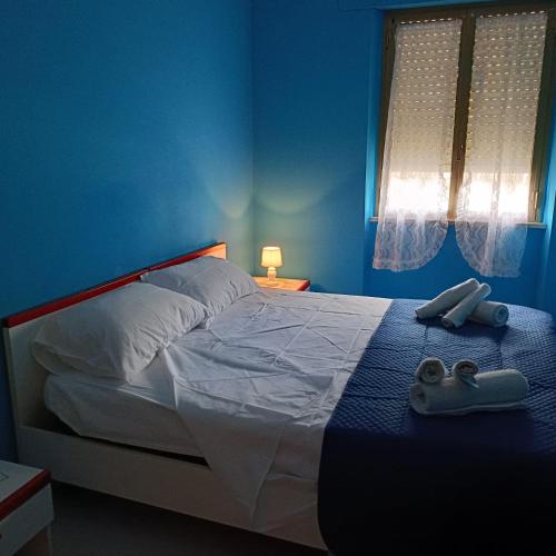 a blue bedroom with a bed with two shoes on it at Azzurro relax in Badesi