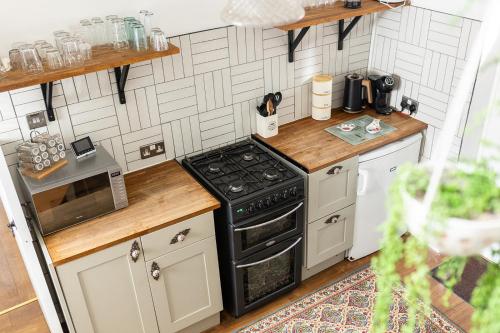 a small kitchen with a black stove top oven at Old Barrel Store - Old Town. Parking & Garden in Margate
