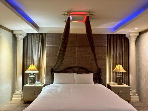a bedroom with a large bed with a red light at Langkei Motel in Daxi
