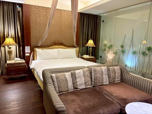 a bedroom with a bed and a couch in it at Langkei Motel in Daxi