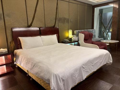 a bedroom with a large bed and a chair at Langkei Motel in Daxi