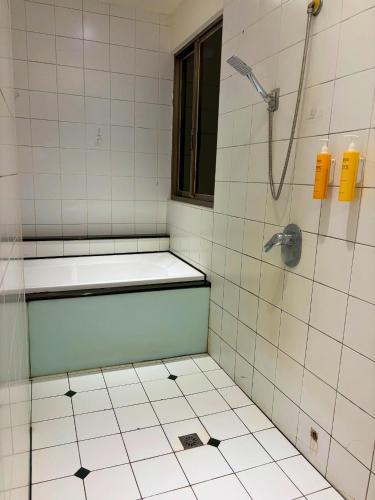 a bathroom with a shower and a tiled floor at Langkei Motel in Daxi