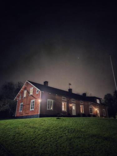 a large brick house at night with lights on it at Orrefors Vandrarhem in Nybro