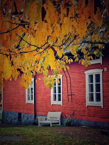 a bench sitting in front of a red house at Orrefors Vandrarhem in Nybro