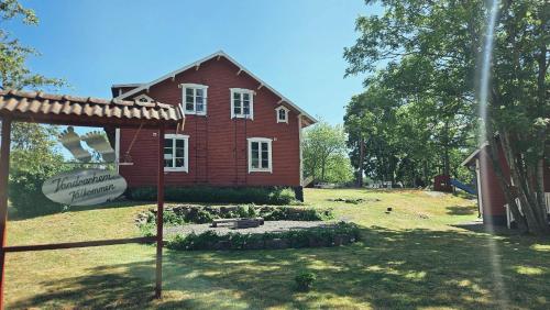 a red house with a sign in front of it at Orrefors Vandrarhem in Nybro