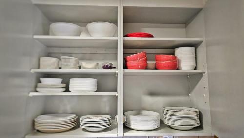 a refrigerator filled with white plates and red bowls at Orrefors Vandrarhem in Nybro
