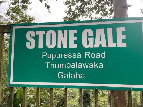 a green sign for a store sale on a fence at Stone gal in Galaha Town