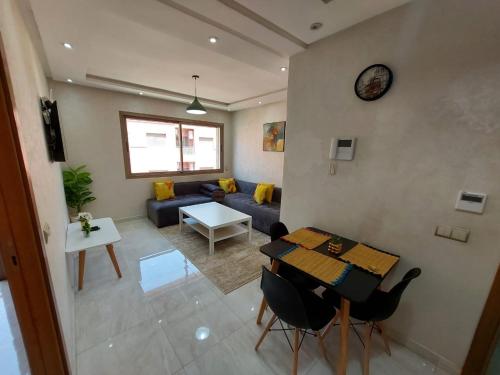 a living room with a couch and a table at Appartement centre ville in Oulad Akkou