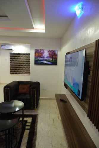 a living room with a flat screen tv on a wall at Tway Apartments in Ilorin