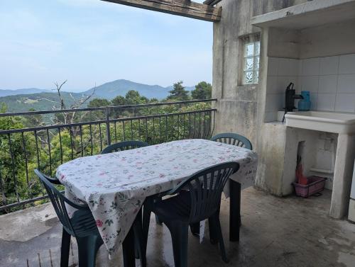 a table and chairs on a balcony with a table and a sink at A cottage with a view in Cévennes for two in Portes