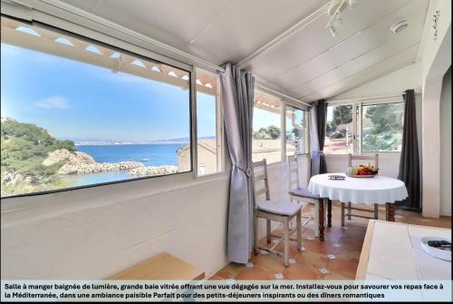 a room with a table and a view of the ocean at "LaCigaleDeNiolon", Vue Mer à 180 & Terrasse, Plage à 50m, Wi-Fi & Netflix in Le Rove
