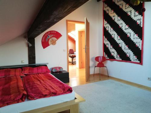 a bedroom with a bed with a red comforter at Großzügige und kunstvolle Dachgeschosswohnung in Leichlingen