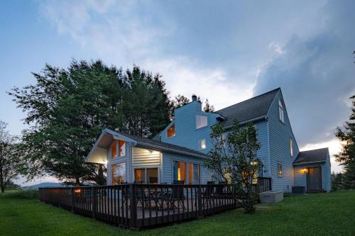 a blue house with a fence in the yard at Panorama Point - Gorgeous views, hot tub, theater in Davis