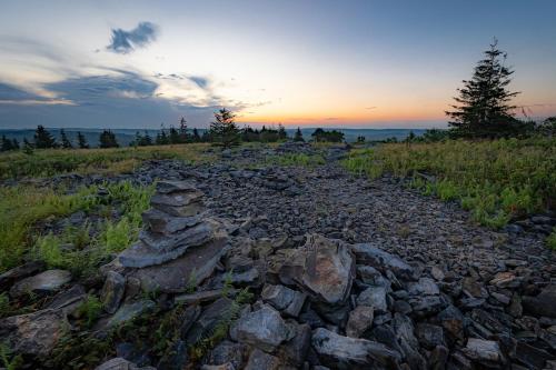 a pile of rocks on a field with the sunset at Panorama Point - Gorgeous views, hot tub, theater in Davis