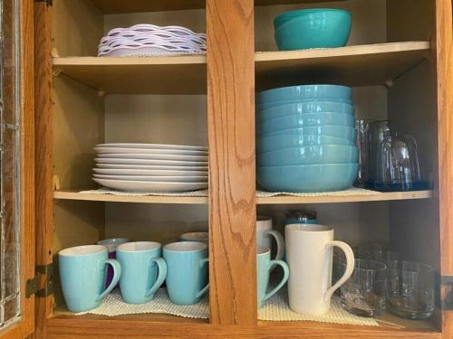 a cabinet filled with blue cups and plates and dishes at Panorama Point - Gorgeous views, hot tub, theater in Davis
