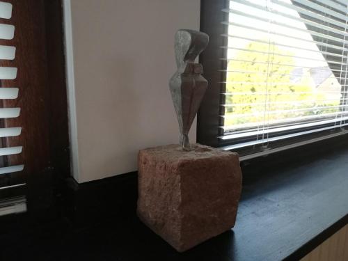a statue sitting on a table next to a window at Großzügige und kunstvolle Dachgeschosswohnung in Leichlingen
