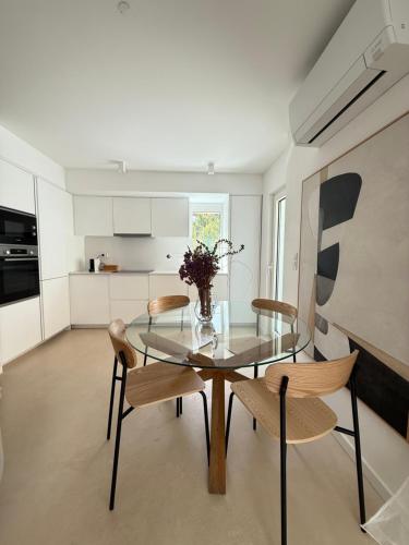 a dining room with a glass table and chairs at Villa Emerald Oeiras Lisbon in Oeiras