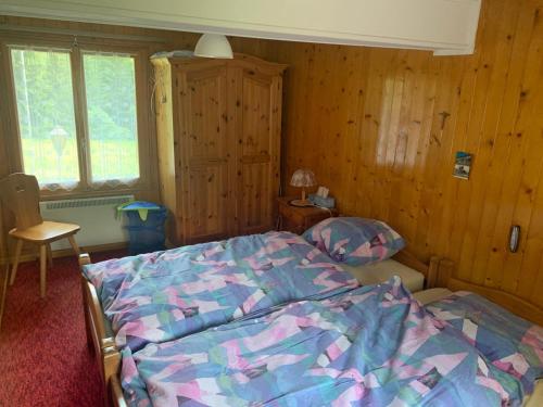 a bedroom with a bed and a wooden wall at Relais de Van d'en Haut in Salvan