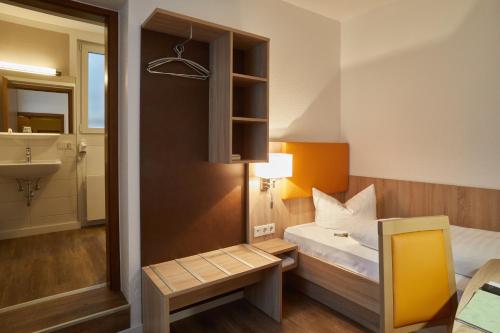 a small room with a bed and a sink at Hotel Zur Traube in Velbert