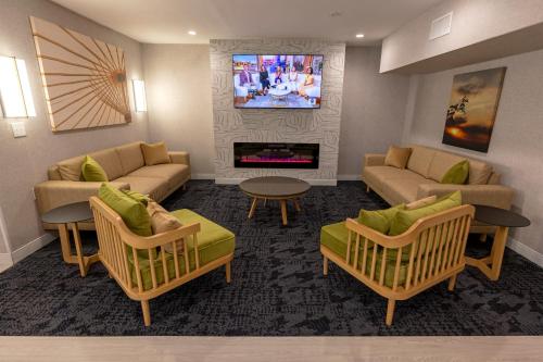a living room with two couches and a tv at Sonesta ES Suites Lafayette Airport Extended Stay in Lafayette