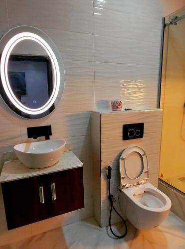 a bathroom with a sink and a toilet and a mirror at The Ambassadors Hotel in Lagos