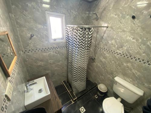 une salle de bain avec un lavabo et des toilettes et une fenêtre dans l'établissement Samsara, à El Chalten