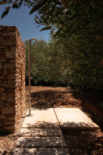 a sidewalk with a pole next to a brick wall at Nine Olives Hvar in Stari Grad