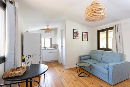 a living room with a blue couch and a table at בקתת המפל הלבן in Eli Ad
