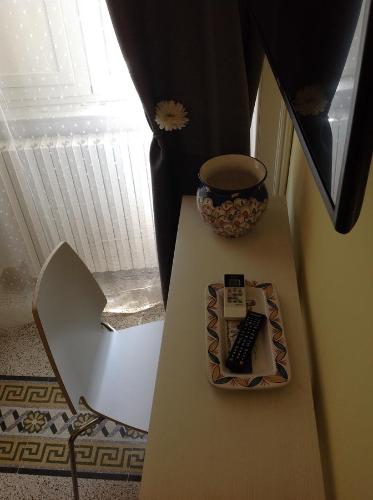 a table with a keyboard and a vase on it at Seawall Holiday Home in Salerno