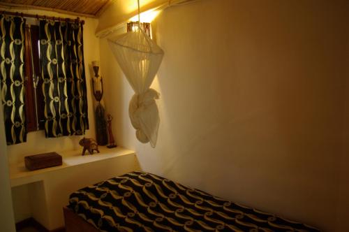 a room with a bed with a lamp and a window at Bed and breakfast Keur Niaye in Toubakouta