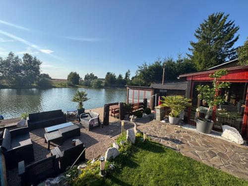 a backyard with a house and a lake at Chata u Rybníka in Žďár nad Sázavou