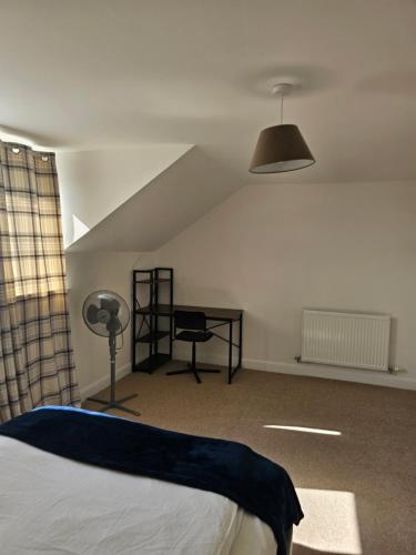 a bedroom with a bed and a desk and a lamp at Large Doubleroom Dartford Central-Close to all amenities in Dartford