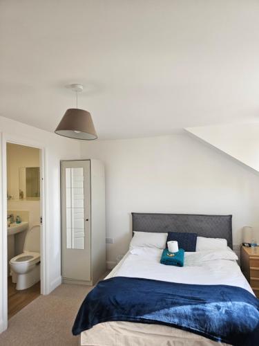 a bedroom with a large bed and a bathroom at Large Doubleroom Dartford Central-Close to all amenities in Dartford