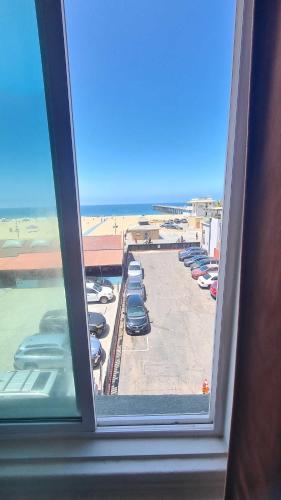 a window with a view of a parking lot at ITH Hermosa Beach Surf Hostel LAX in Hermosa Beach