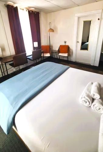 a bedroom with a large bed with towels on it at ITH Hermosa Beach Surf Hostel LAX in Hermosa Beach