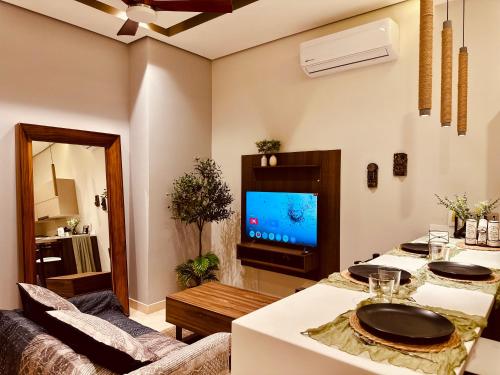 a living room with two tables and a television at Jungle Guardian - Rooftop Pool & Beach Club in Zona Hotelera Tulum in Tulum